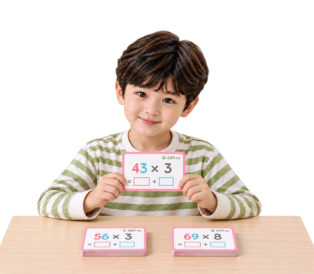 43×3 카드를 들고 책상에 곱셈 카드를 펼쳐 둔 아이